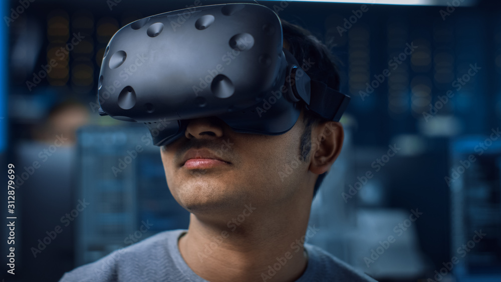Leinwandbilder Close-up Portrait of Software Delevoper Wearing Virtual Reality Headset to Develop and Program VR Gaming and Applications. In the Background Technology Developing Studio with Computers and Monitors