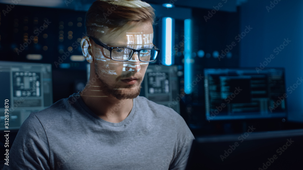 Wall mural Portrait of Software Developer / Hacker Working on Computer, Projected Code Numbers and Characters Reflect on His Face. Dark Room Full of Electronics, Computers, Displays. Hacking or Programming