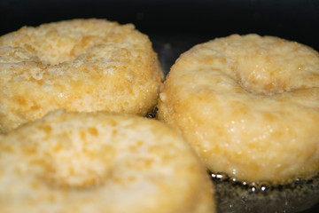 Three minced chicken cutlets are fried in a pan in vegetable oil. Close up.