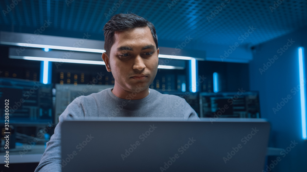 Poster Portrait of Software Programmer Sitting at His Desk and Working on Computer in Digital Identity Cyber Security Data Center. Hacking or Programming.