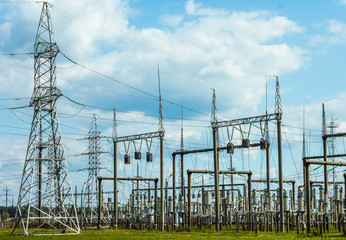 electric energy: power plant (towers, wires, transformers) in a field, blue sky, ecology