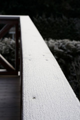 balcony railing with the first light snow.
