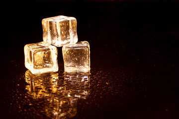 Golden ice cubes on black background.