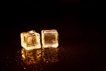 Golden ice cubes on black background.