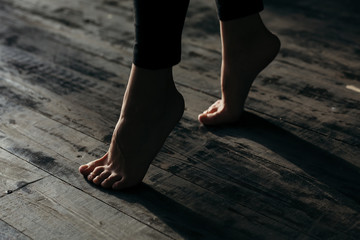 Female feet walking on warm heated floor close up view, barefoot girl legs going on hardwood living...
