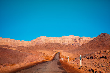 Driving a car on a mountain road in the desert. View of sandstone mountains through the windscreen. Timna Park, Israel