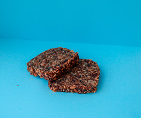Sliced whole grain bread rye with seeds flax, sunflower, pumpkin and sesame.Healthy food, eco-friendly natural products. Fresh bread on a blue background.