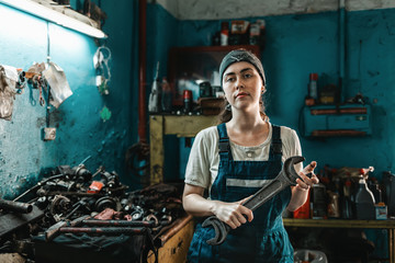 The concept of small business, feminism and women's equality. A young woman in overalls poses with...