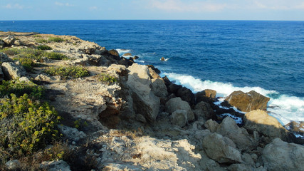 Fototapeta na wymiar rocky shore of the blue sea, waves, white foam