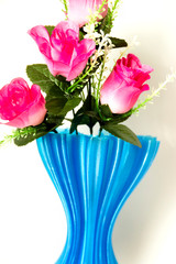 blue cup full of small pink roses