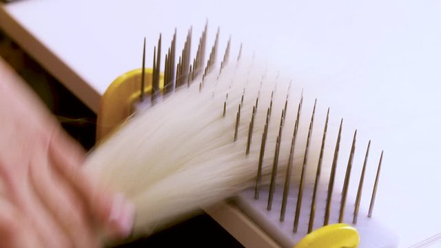 Hair combing when creating a wig. Factory wig production process