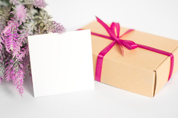 Valentine's Day background with a gift, white paper card and lavender flowers on a white background, copy space for text