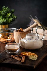 Milk spicy Indian tea Masala in a teapot with cinnamon, cloves and anise. Oriental tea ceremony on...