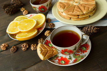 Fototapeta premium homemade shortbread cookies with coffee or tea and lemon. Beautiful vintage cups on a wooden table.