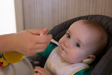 little kid boy eating porridge with appetite.