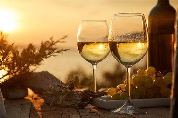 two glasses with wine during sunset time