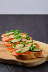 Sandwich with salmon on wooden plate with copy spase
