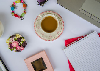 Coffee in the office, close-up of the desk with different objects, beautiful decorated cup with hot beverage, business concept