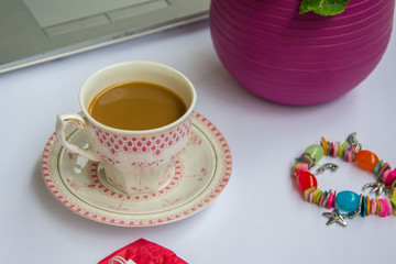 Coffee in the office, close-up of the desk with beautiful decorated cup with hot beverage, business concept