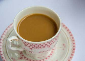 Coffee in the office, close-up of the desk with beautiful decorated cup with hot beverage, business concept