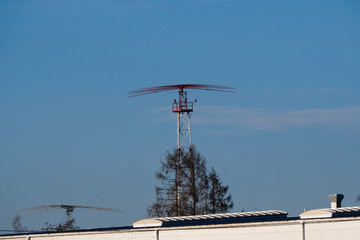 antenna at the airport, radar system near the airport, against a blue clear sky with a small cloud....
