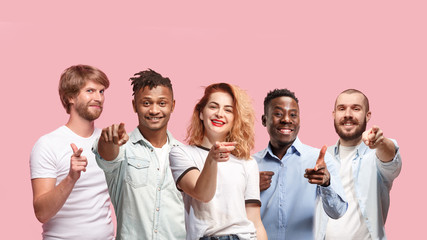 Portrait of multiethnic group of young people isolated on pink studio background, flyer, collage....