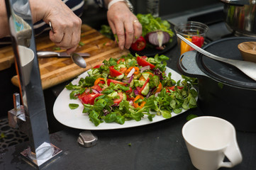 Female cook mixing chopped vegetables