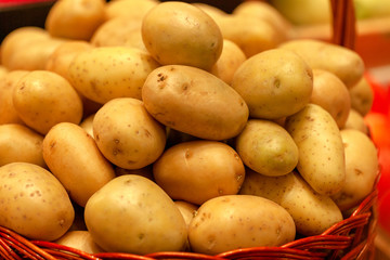 Potatoes closeup image at food market. Wicker basket with potatoes closeup. Harvesting potatoes. 
