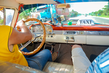 interior of car taxi. White leather car interior. Varadero is resort town in province of Matanzas, Cuba. Dashboard, steering wheel and door.