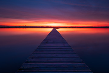 Obraz na płótnie Canvas Very colorful and tranquil dawn at a jetty in a lake. Groningen, Holland.