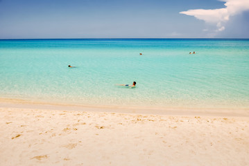 Man lies on yellow deck chair on white sand. Beach chair. Scene with sailing boat at famous...