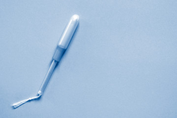 Medical female tampon with applicator with copy space in classic blue. Concept of health care, femininity, hygiene