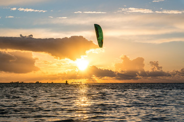 Wide shot of kitesurfer riding in beautiful yellow sunset conditions at the Greifswalder Bodden near the baltic sea