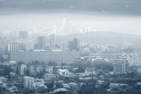 Monochrome image of a cityscape in dense fog.