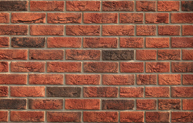 Decorative wall texture, background. Rusty, matted, red bricks. The fragment of a new stylish decorative bricklaying. Vintage and antique style in exterior of the house
