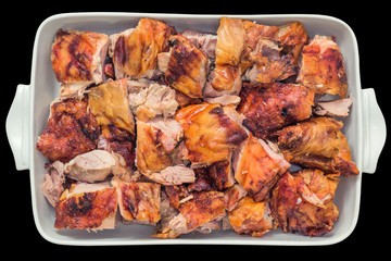 Plateful of Fresh Spit Roasted Pork Thigh Meat Slices Served in White Ceramic Casserole Pan Isolated on Black Background