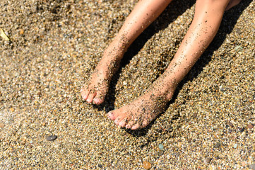 children's feet in the sea sand and water