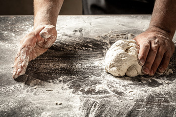 Male hands making dough for pizza, dumplings or bread. Baking concept. chef with raw dough
