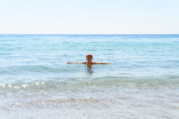 six years old little girl having fun at summer vacation in sea with her family
