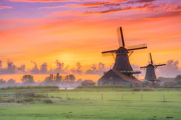 Fotobehang Traditional village with dutch windmills and river at sunset, Holland, Netherlands. © gatsi