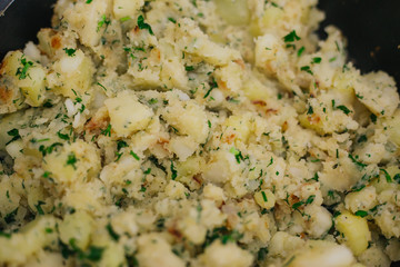 Potatoes with greens in a pan. Stewed potatoes with dill.