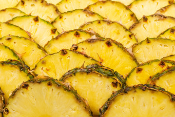 Pineapple juicy yellow slices background. Top view.