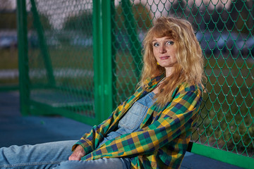 Portrait of redhead ginger girl weared in casual style denim jumpsuit and plaid shirt