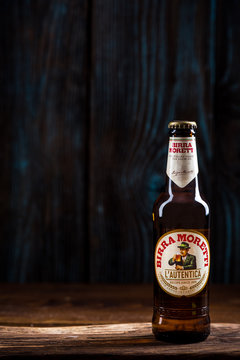 TARNOW, POLAND - SEPTEMBER 24, 2018:  Bottle of Italian beer Birra Moretti on wooden background.