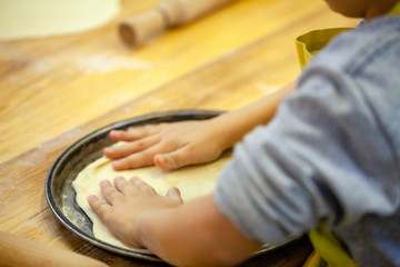 Children cooking pizza. Photo of children hands cooking Italian food. Process of cooking pizza by children in the master class. 