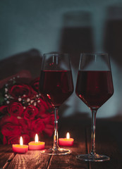 Two Glasses of Wine With Roses and Burning Candles