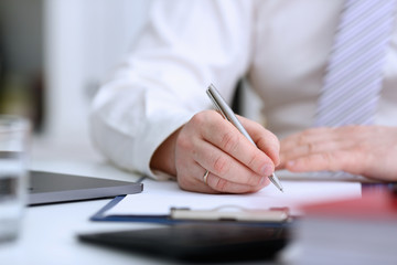 Male arm in suit and tie hold silver pen