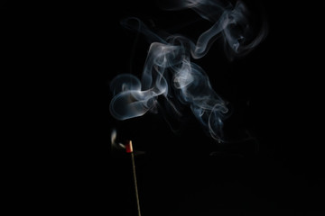 abstract background of smoke from incense stick close up with copy of space on black background. Focus on the smoke
