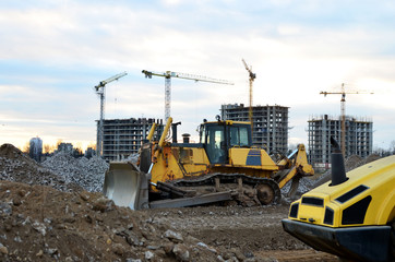 Track-type bulldozer on construction site. Land clearing, grading, pool excavation, utility trenching and foundation digging during of large construction jobs. Earth-moving equipment