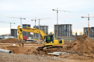 Excavator digs the ground for the foundation and construction of a new building. Road repair, asphalt replacement, renovating a section of a highway, laying or replacement of underground sewer pipes